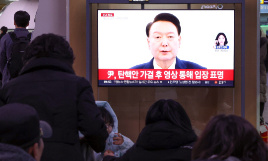 윤석열 대통령의 탄핵소추안이 국회에서 가결된 14일 오후 서울역에서 시민들이 윤석열 대통령의 대국민 담화를 TV를 통해 지켜보고 있다. [연합뉴스]